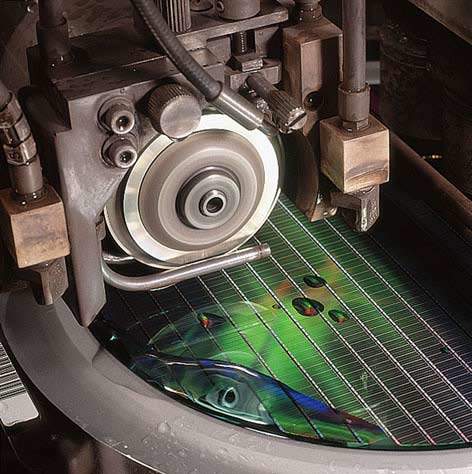At wafer saw, a diamond-edged blade cuts the finished wafer into the individual dice.