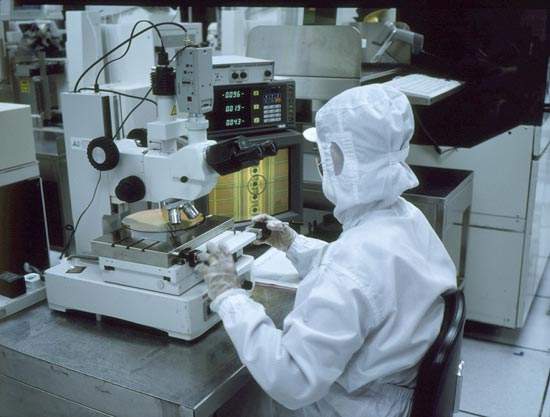 Operator visually inspecting a wafer.